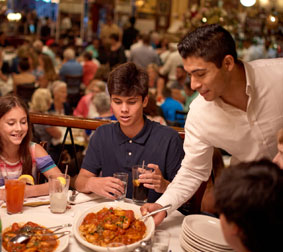 Food server placing large plate of food on table